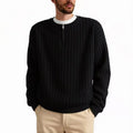 Man wearing a grey textured knit half zip sweater with a loose fit and long sleeves.