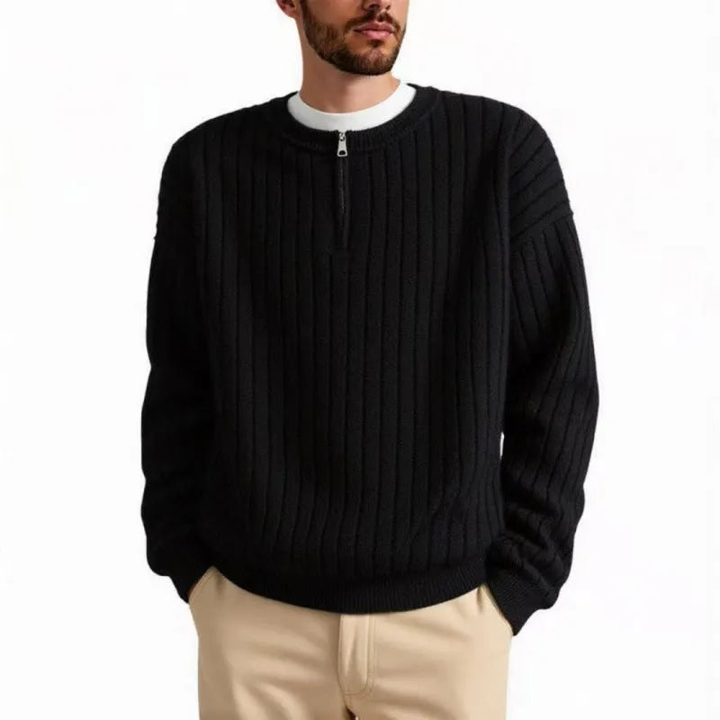 Man wearing a grey textured knit half zip sweater with a loose fit and long sleeves.