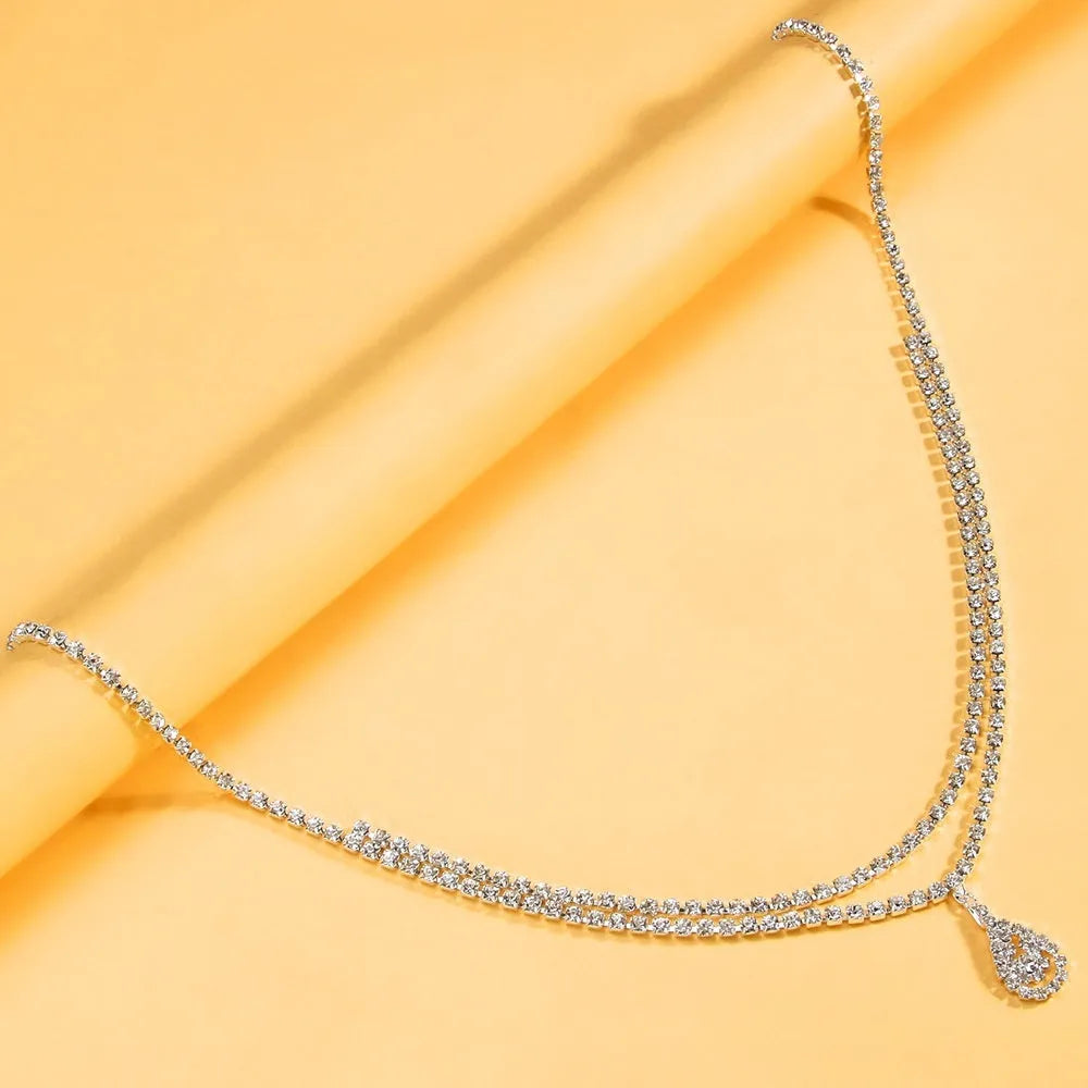 Gold and silver water drop pendant waist chain for women with rhinestones and tassel detailing.