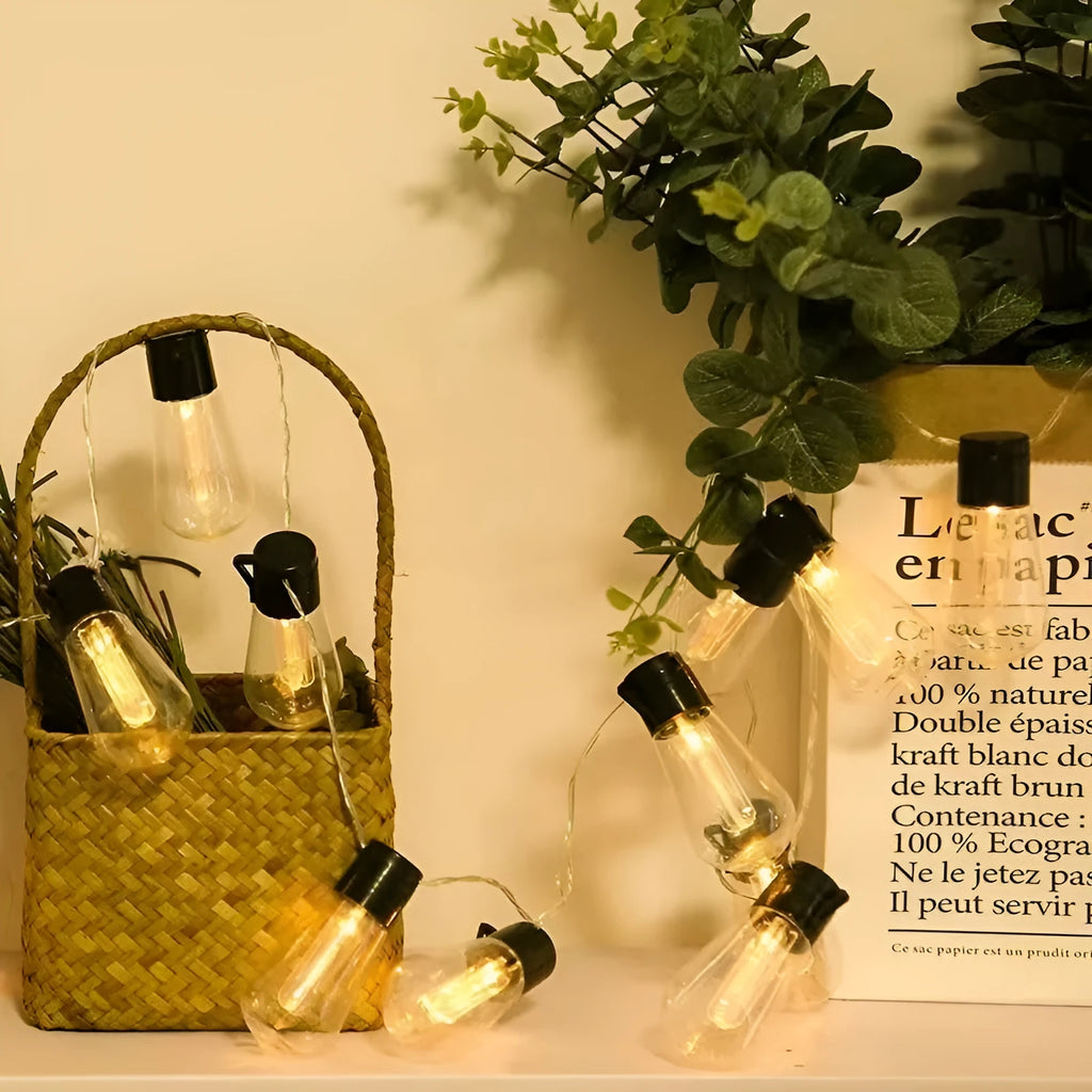 Retro infusion bottle shaped glass bulb outdoor string lights in garden setting