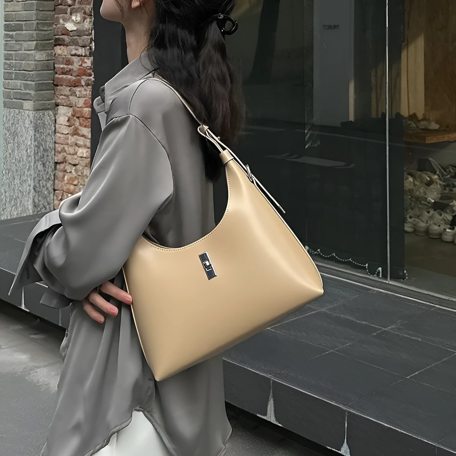 Women's soft genuine leather crossbody shoulder bag in a dumpling shape, shown in a light colour.
