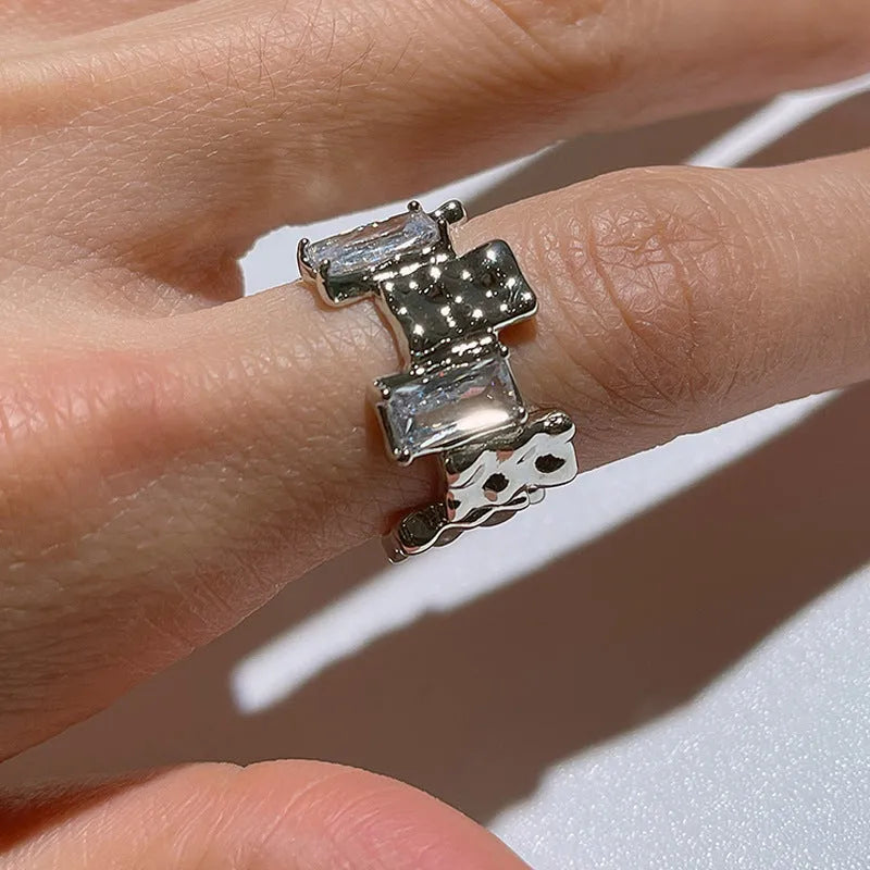 Silver geometric cross ring with zircon detailing and open gemstone setting
