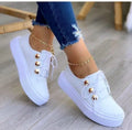 Women's lace-up flats sneakers with rivet detailing in gold colour showing round toe and front tie closure