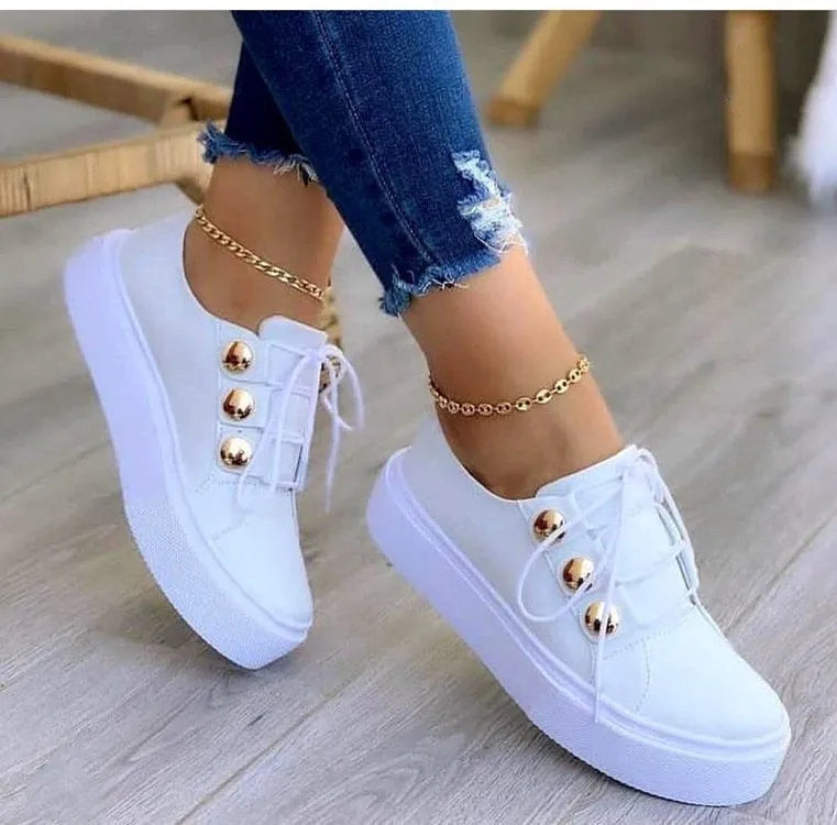 Women's lace-up flats sneakers with rivet detailing in gold colour showing round toe and front tie closure