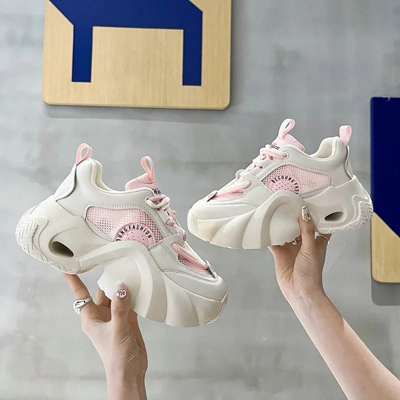Women's pink sneakers with cross straps and thick sole showing side profile