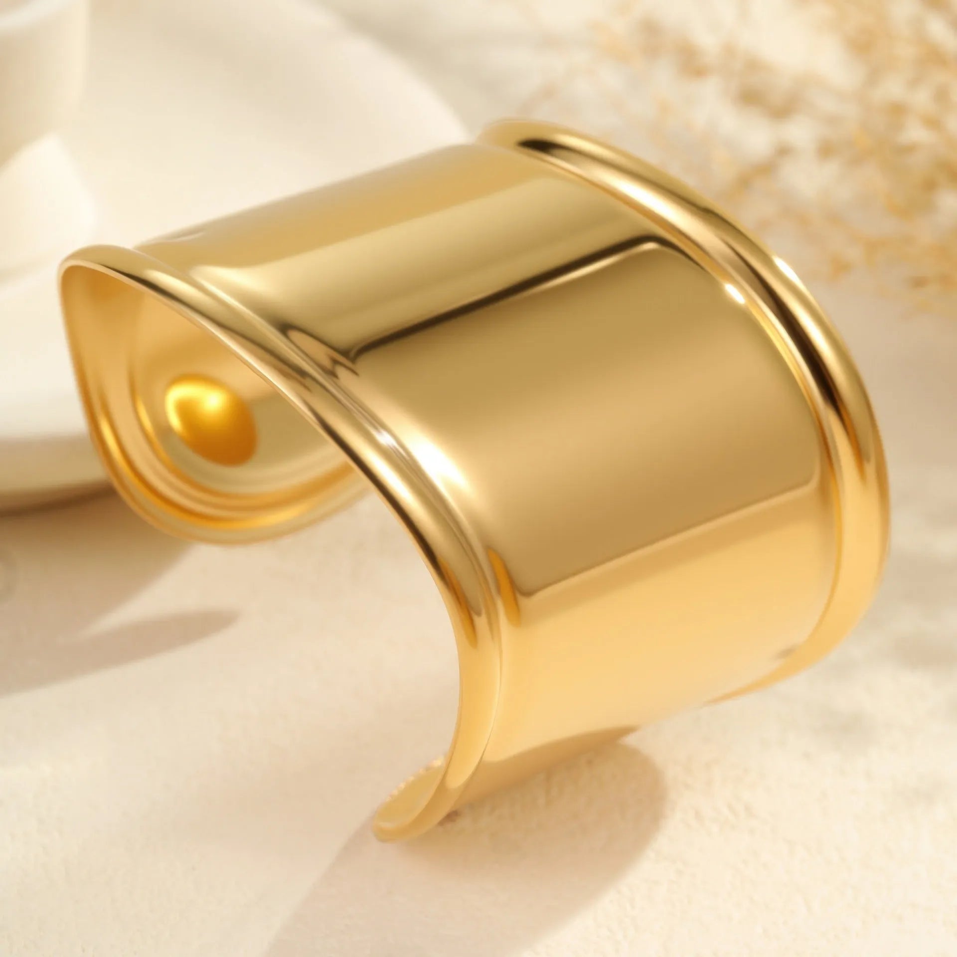 Women's wide stainless steel bracelet with gold plating and wave geometric pattern