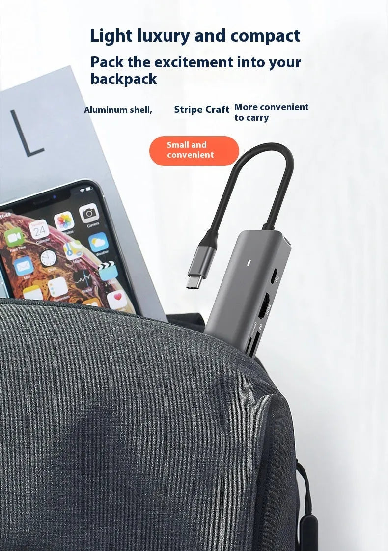 Silver USB C 7-in-1 hub dongle with SD card slot, micro SD slot, and USB C PD charging port.