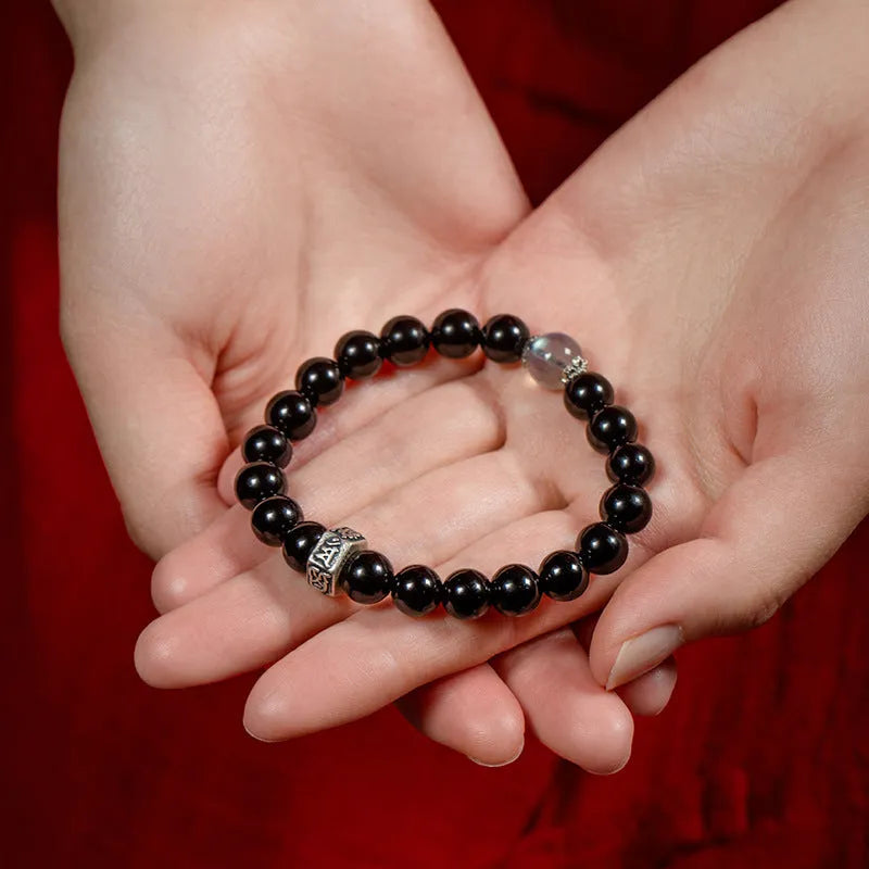 Old Pit Obsidian 8mm bracelet with detailed metal zodiac animal and Buddhist bodhisattva charms.