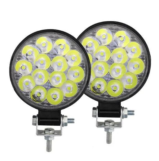 Compact round white LED work light with aluminium housing, suitable for mounting on a vehicle.