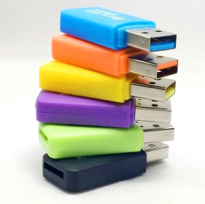 Black and silver Mini USB card reader for microSD and SD memory cards on a desk.