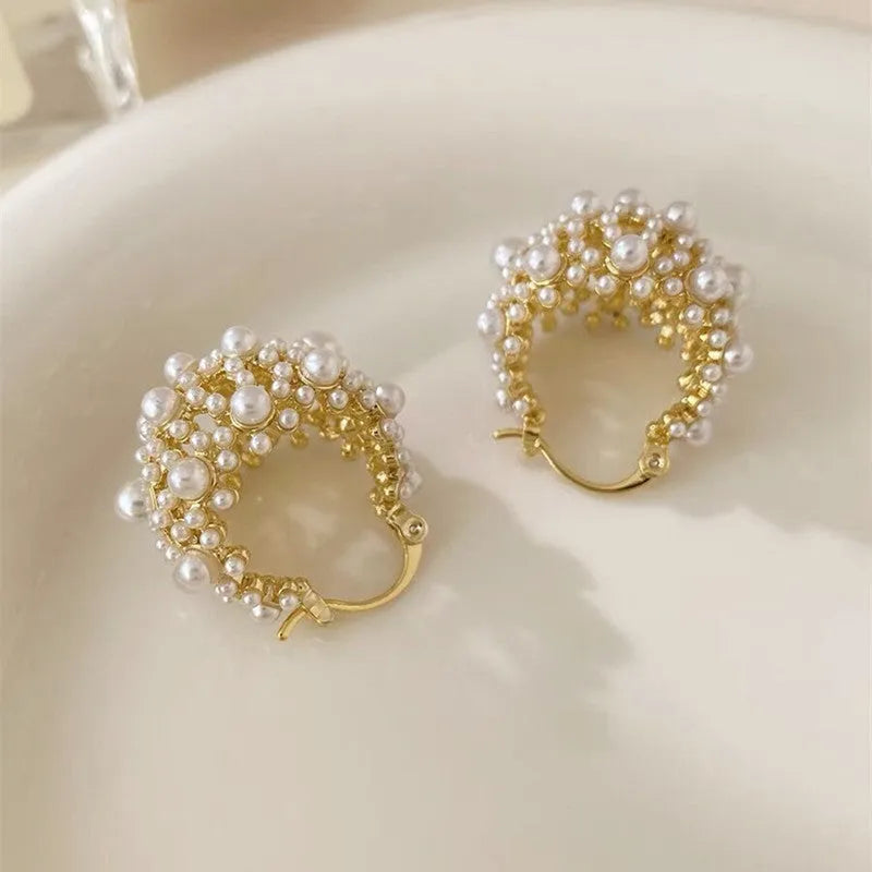 Women's gold flower basket earrings with small beads and pearl inlay detailing on copper