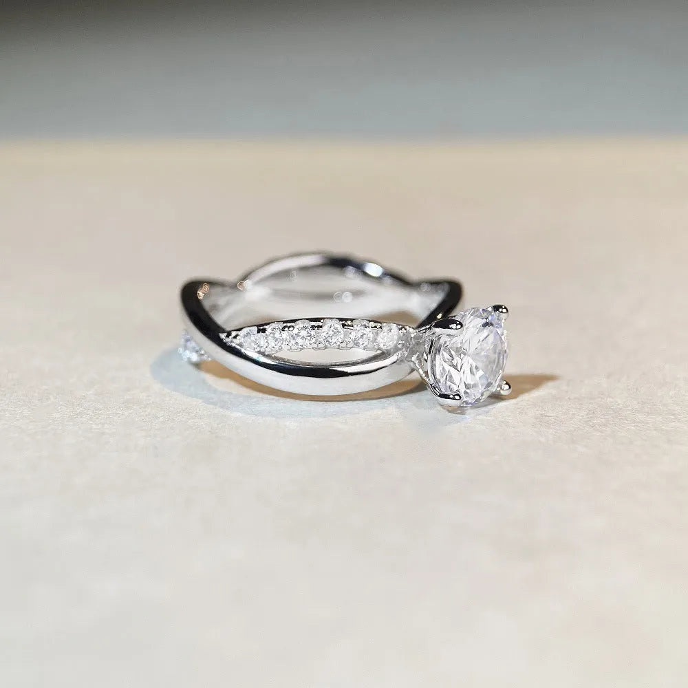 Silver geometric cross ring with a 1 karat moissanite stone and twisted band.
