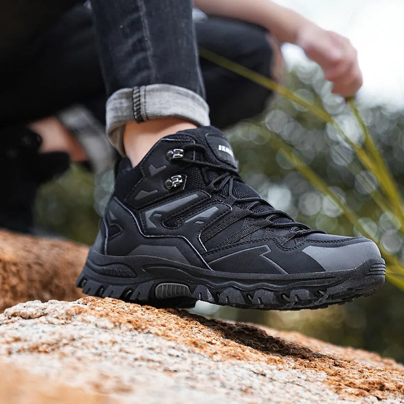 Men's black flannel high-top hiking sneakers with rubber sole and lace-up front on a rocky path.