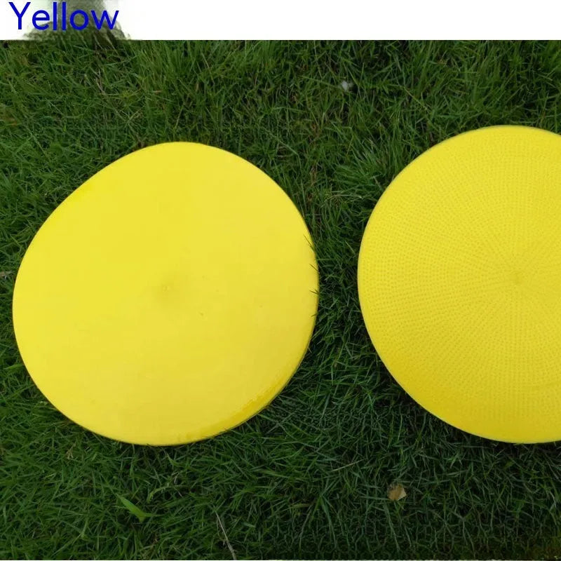 Soft TPE football training marker disc in yellow, 23 cm diameter, lying flat on grass.