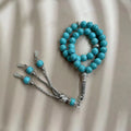 Sky blue stone bead Muslim prayer bracelet on wrist, handmade with elasticated cord.