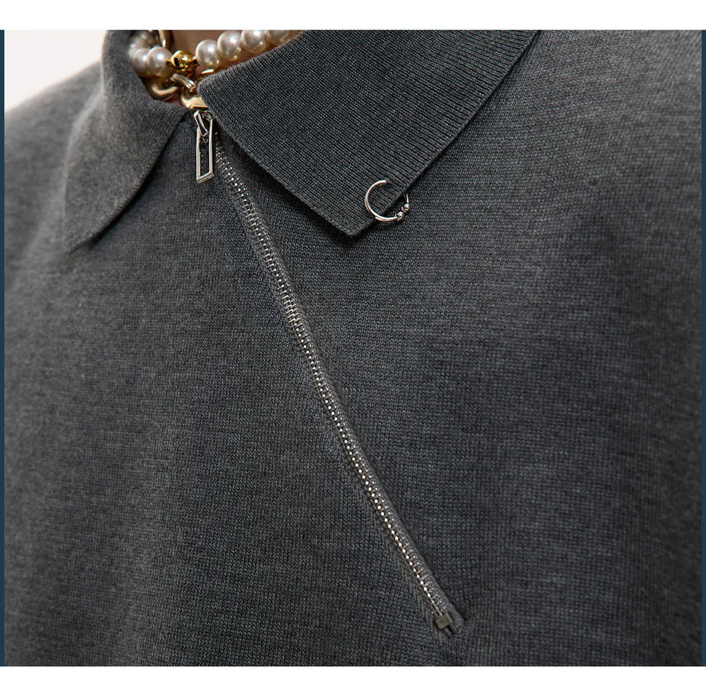 Man wearing a slim-fit black knitted polo shirt with a diagonal zip on the lapel collar.