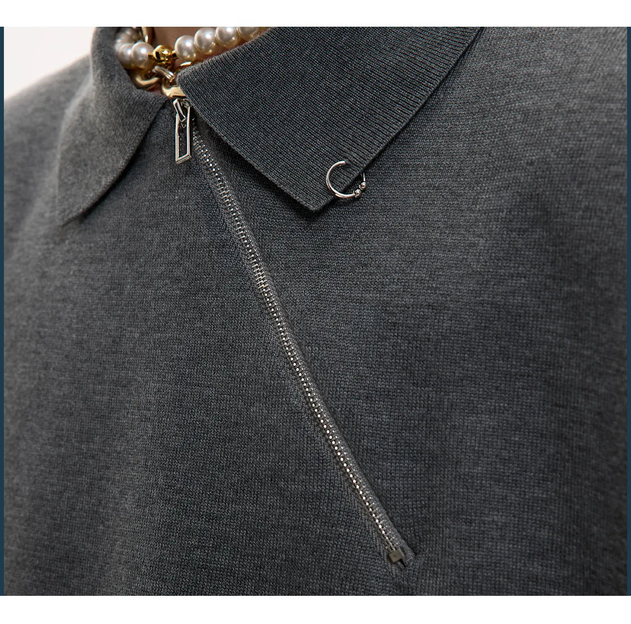 Man wearing a slim-fit black knitted polo shirt with a diagonal zip on the lapel collar.