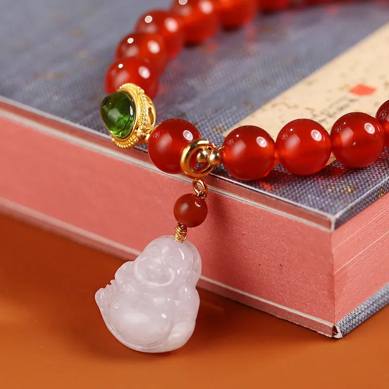 Handmade red agate and amber bracelet with geometric beads and a gold Maitreya Buddha charm.