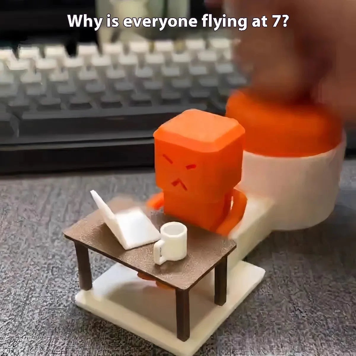 Orange plastic Take a Shot vent decompression toy with a rotating table on a desk.