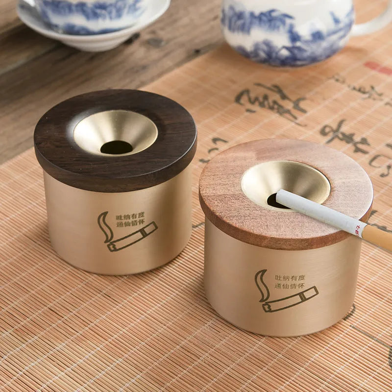 Brass ashtray with wooden lid showing centre hole design and copper construction