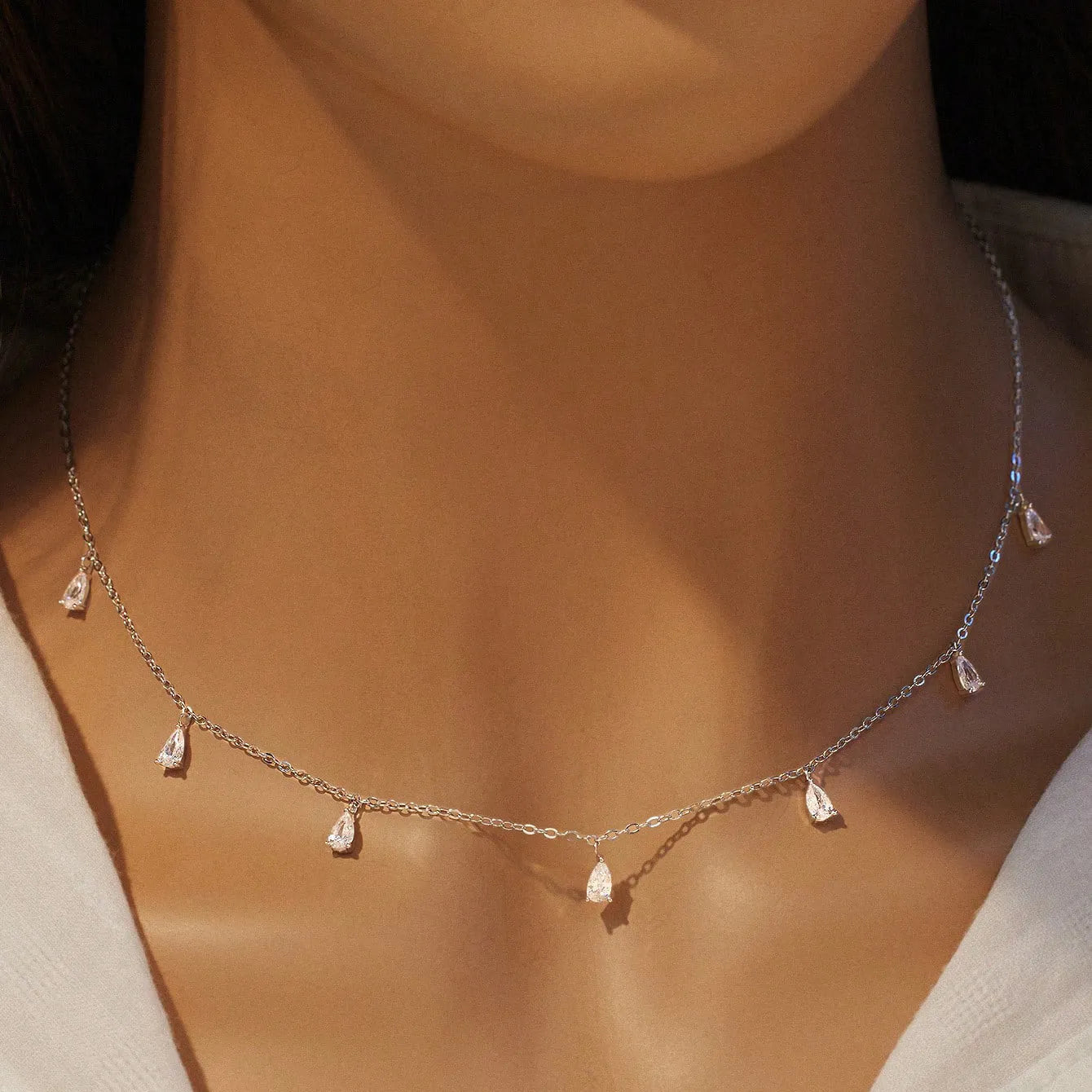 Sterling silver necklace with drop-shaped artificial zircon pendant on adjustable chain in silver, rose gold, and golden yellow finishes