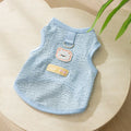 Green knitted cat clothing with a bear patch, showing hollowed-out breathable fabric.