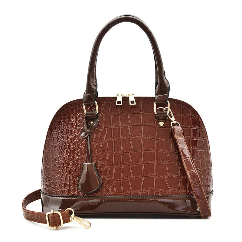 Large shiny PU leather crossbody shoulder bag in shell shape, showing black, red, and brown colour options