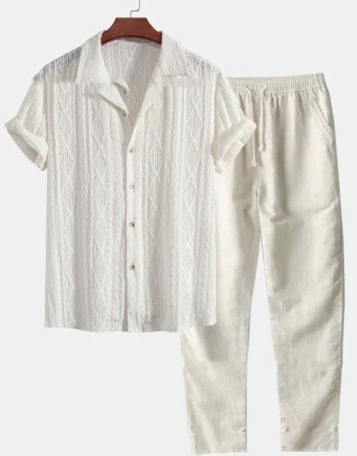 Man wearing a loose fit short sleeve shirt and matching trousers from a milk silk polyester summer suit set.