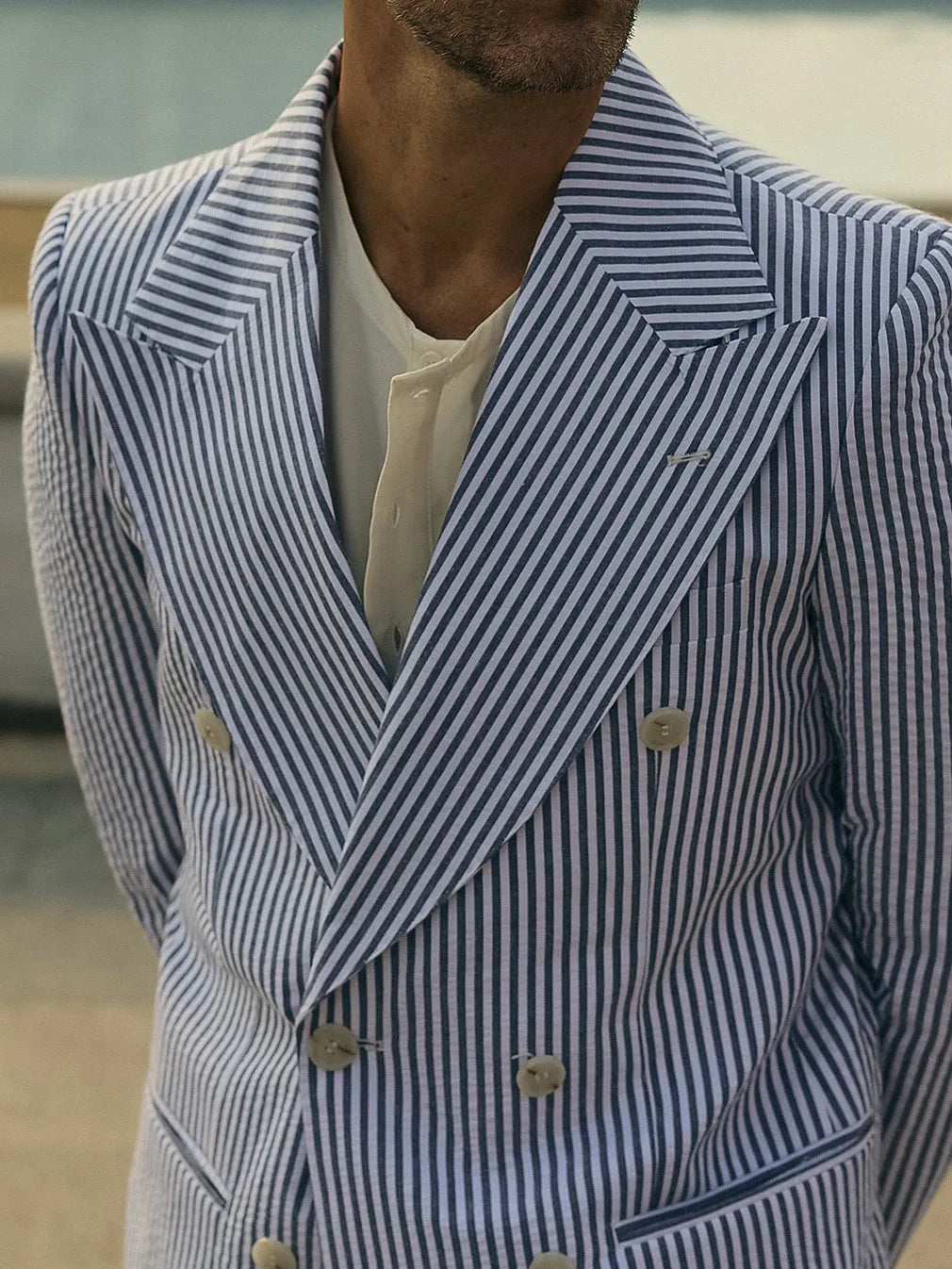 Blue and white striped men's suit set with polyester blazer and trousers on hanger