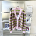 Pink women's wool knitted cardigan on a hanger, showing nap texture and regular sleeves.