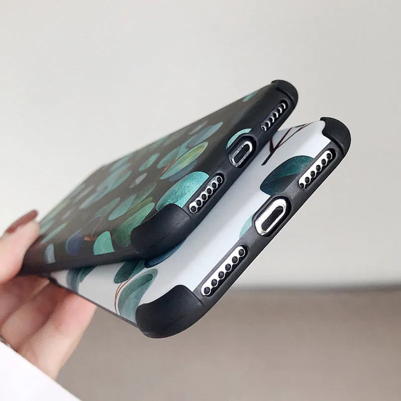 Black silicone iPhone case featuring a decorative leaf print design on the back.