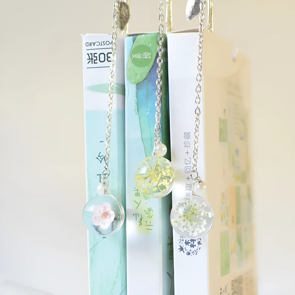 Dried flower specimen bookmark with alloy metal pendant in blue starry sky design.