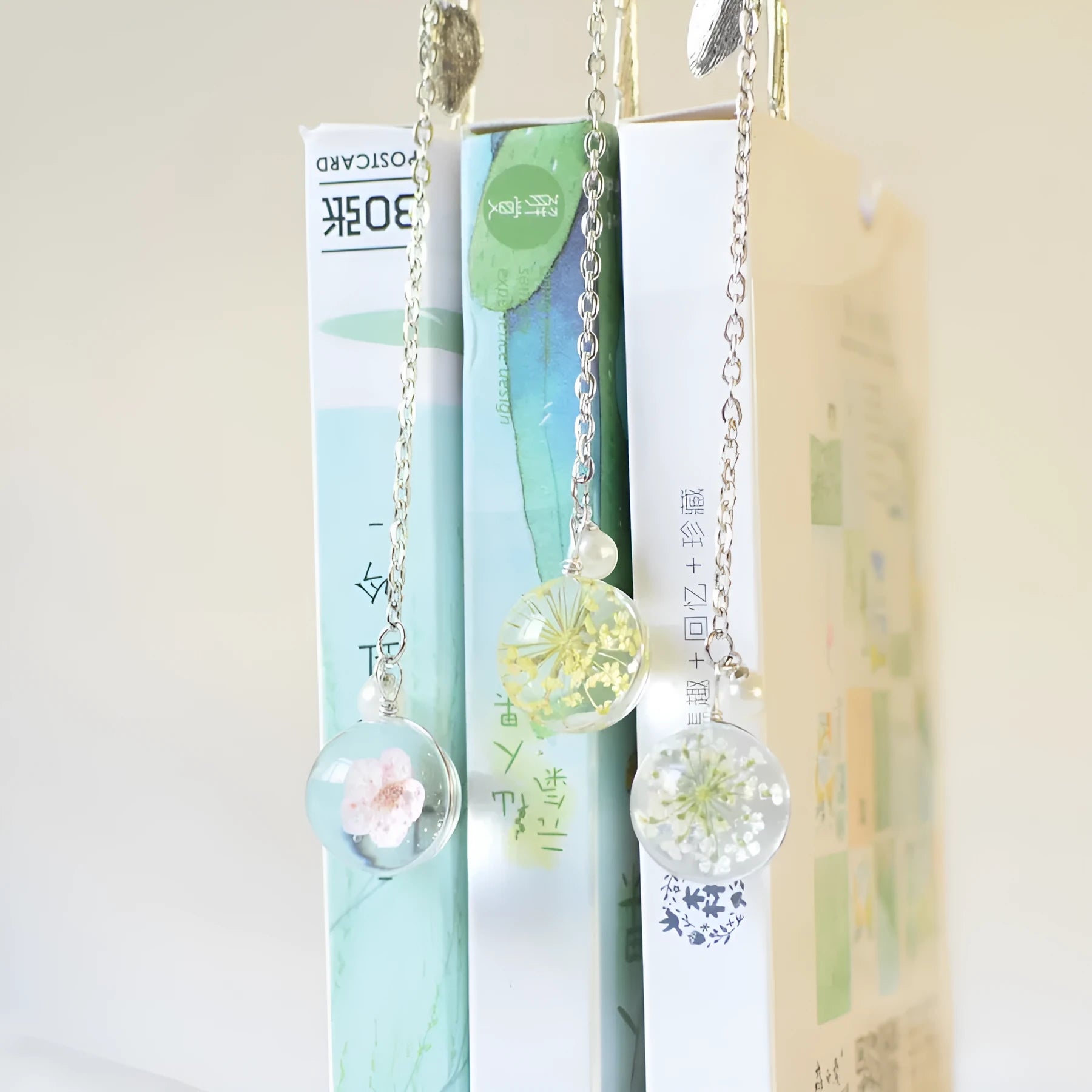 Dried flower specimen bookmark with alloy metal pendant in blue starry sky design.