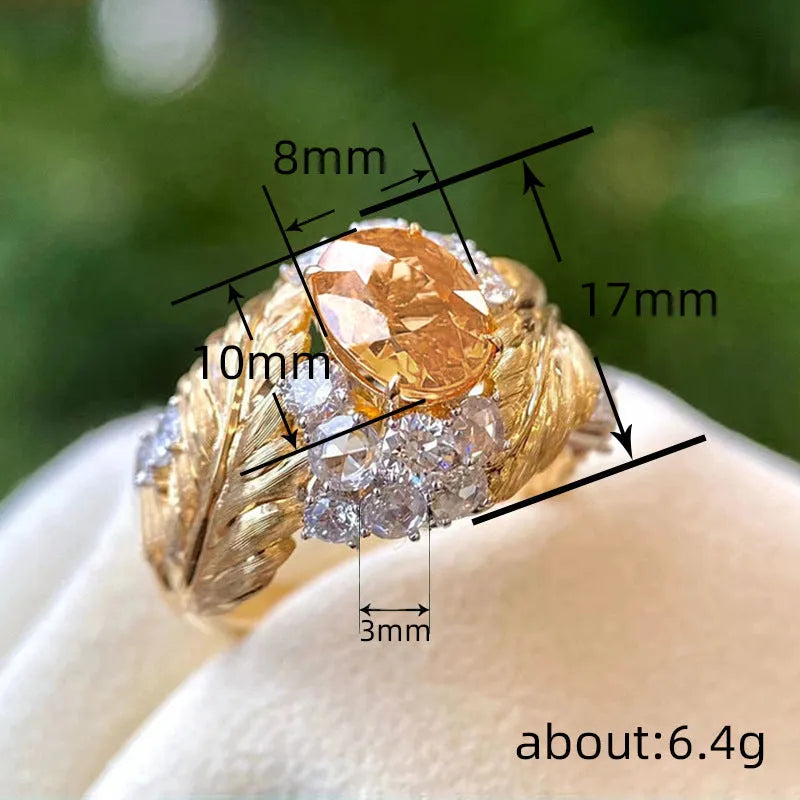 Gold-coloured copper feather ring with geometric design and yellow zircon inlay details