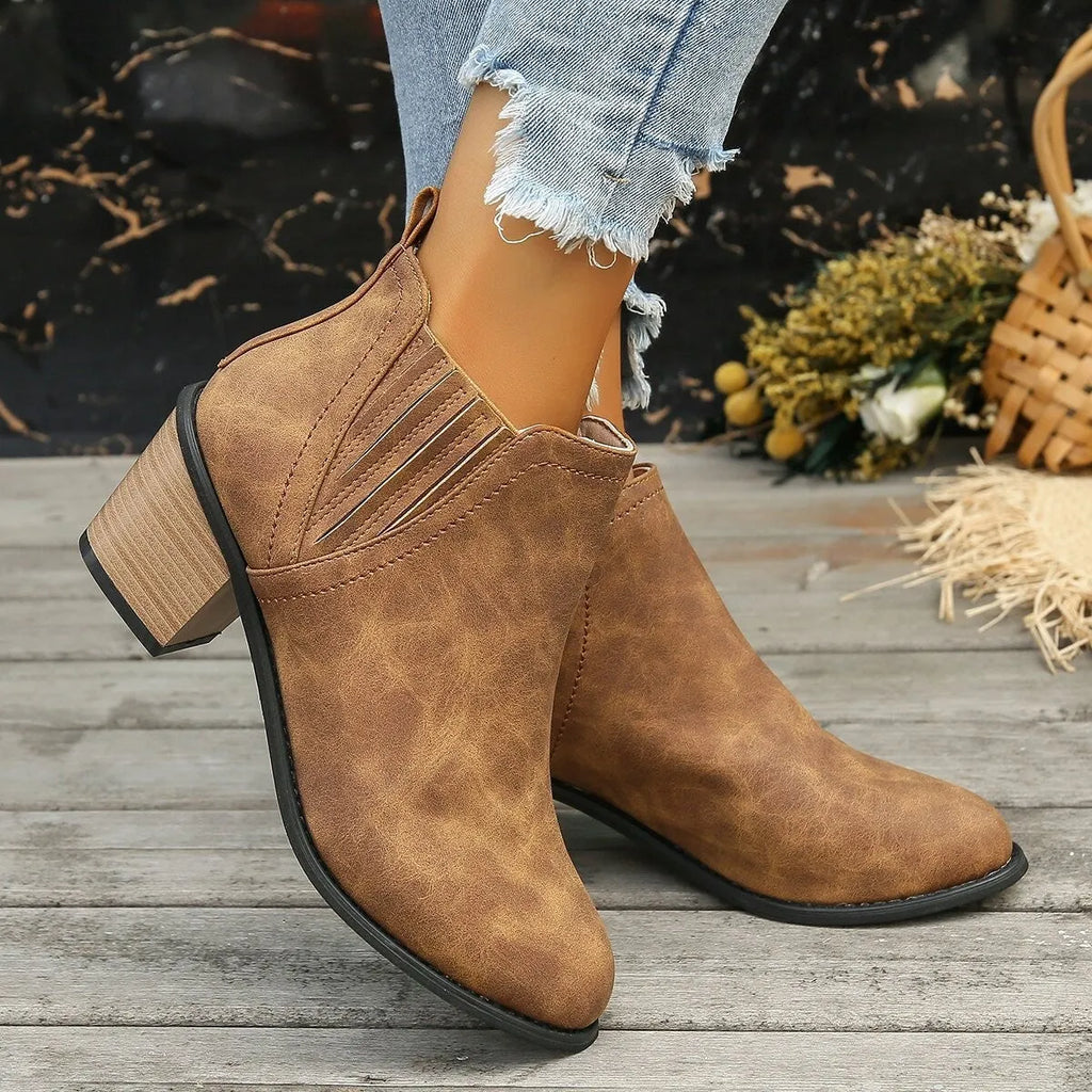 Women's black pointed toe ankle boots with a thick square low heel and slip-on design.