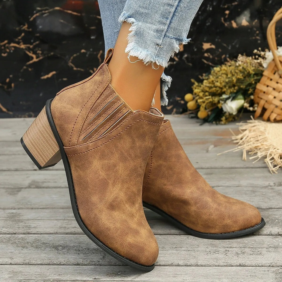Women's black pointed toe ankle boots with a thick square low heel and slip-on design.