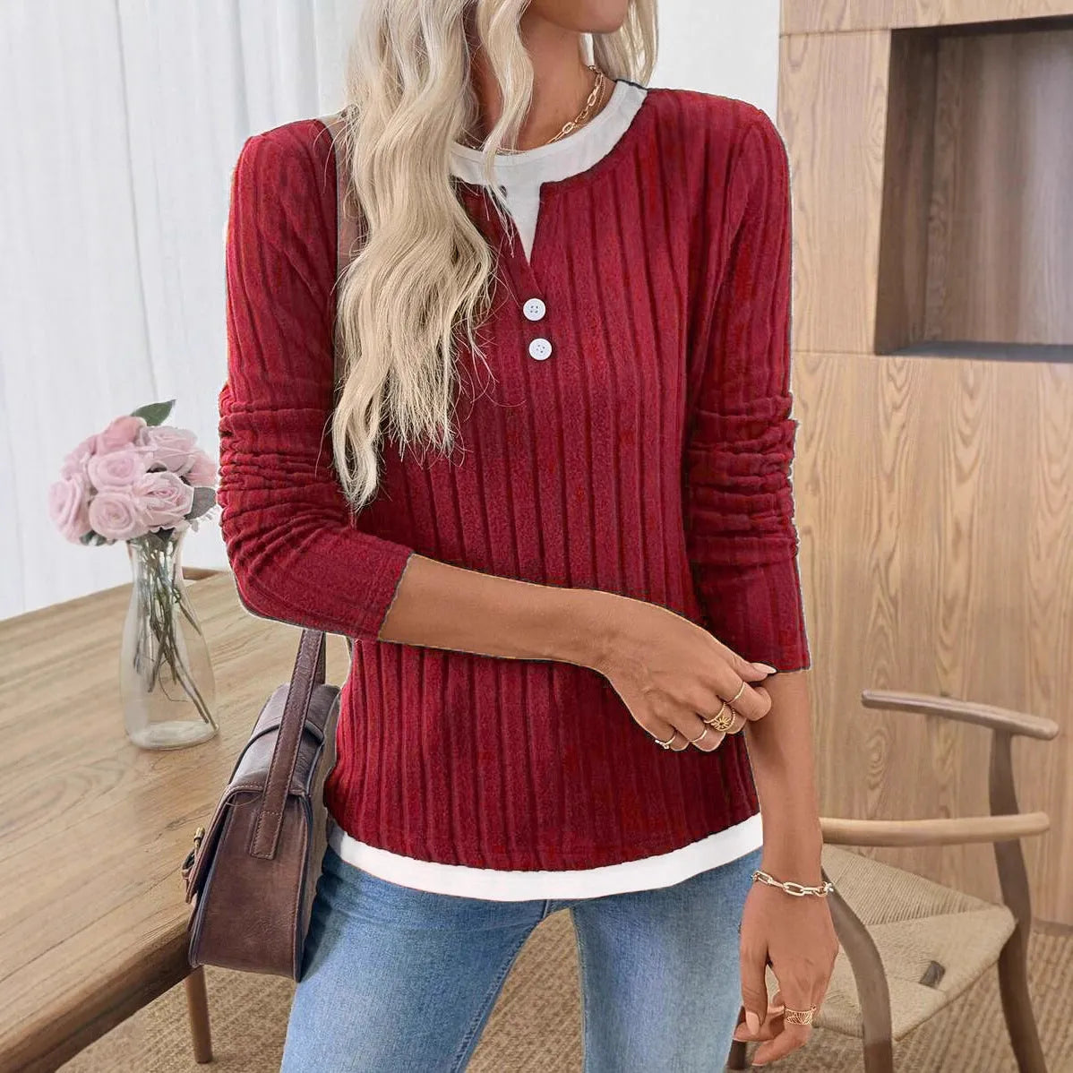 Women's black fake two-piece pullover sweater with button front and round neck on a model.