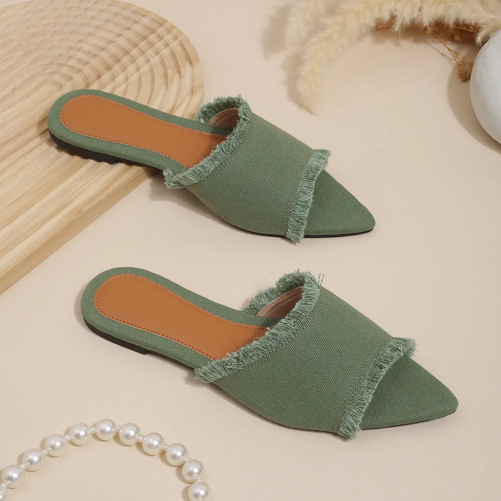 Women's denim flat slippers with tassel detail in apricot colour on a white background.