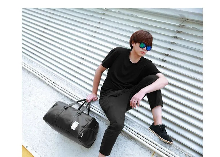 Large black waterproof sports gym bag with separate side shoe compartments and a diagonal carry strap.