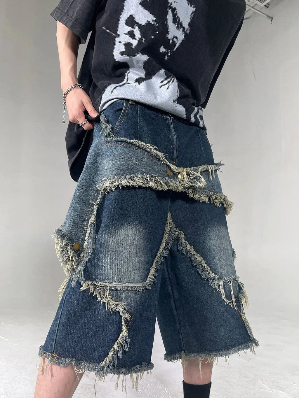 Blue denim shorts with a frayed five-pointed star detail on the leg, showing a loose, retro fit.
