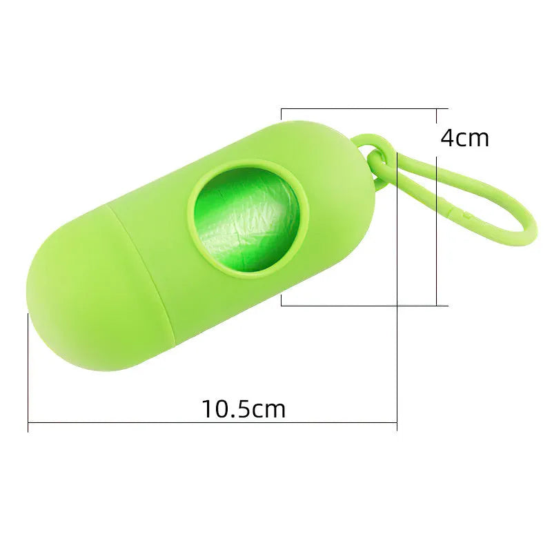 Compact black dog poop bag dispenser with side hook and Velcro strap, shown next to a roll of waste bags.