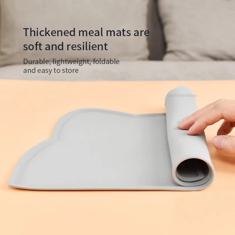 Blue silicone pet feeding mat with cat head design under food and water bowls
