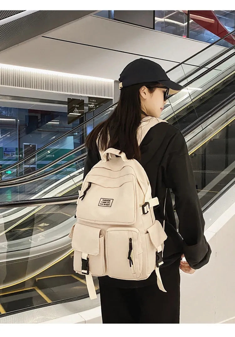Black and white nylon student backpack with laptop compartment and three-dimensional outer pockets.