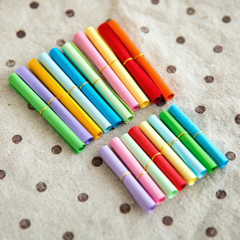 Colourful assortment of small rolled paper scrolls with central holes for drift bottle messages