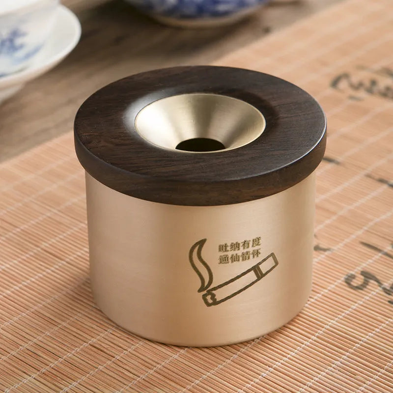 Brass ashtray with wooden lid showing centre hole design and copper construction