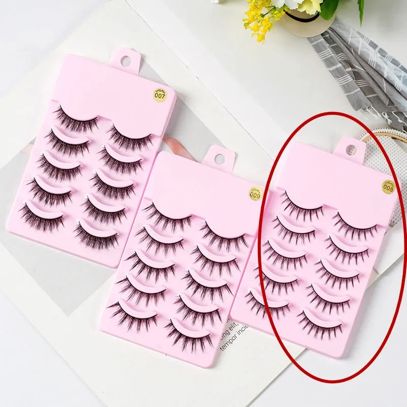 5 pairs of manga-style false eyelashes on a black strip, showing natural wispy Korean makeup look.
