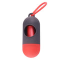 Compact black dog poop bag dispenser with side hook and Velcro strap, shown next to a roll of waste bags.
