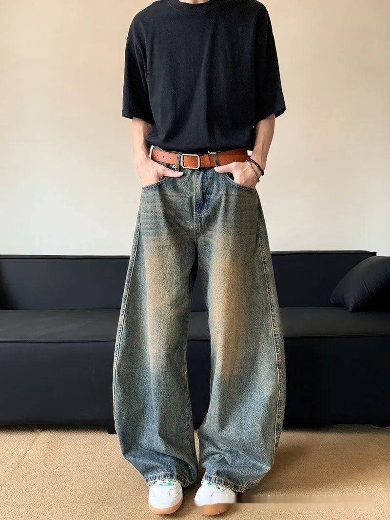 Man wearing retro blue distressed wide-leg denim jeans with a slimming fit and mid waist design.