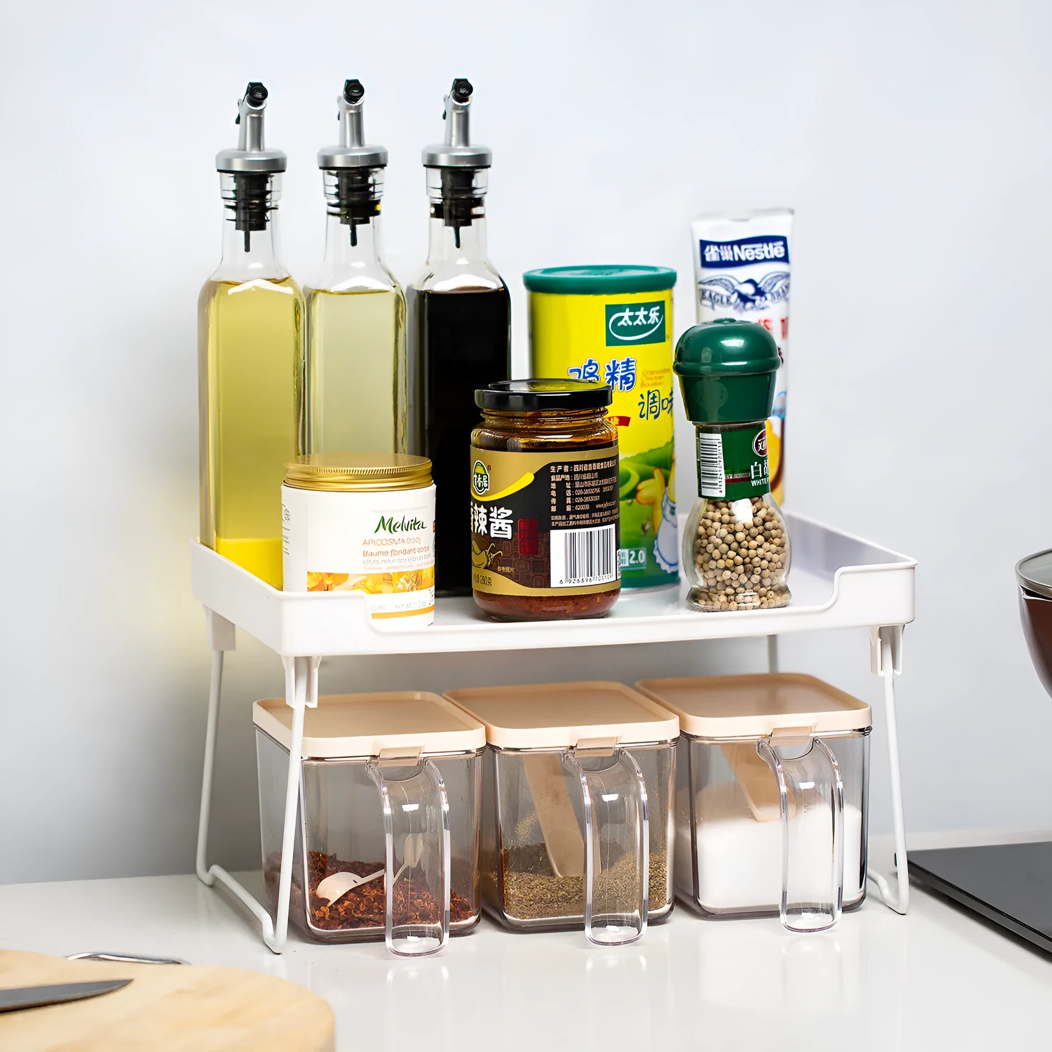 White plastic kitchen supplies rack holding bottles and jars on a countertop