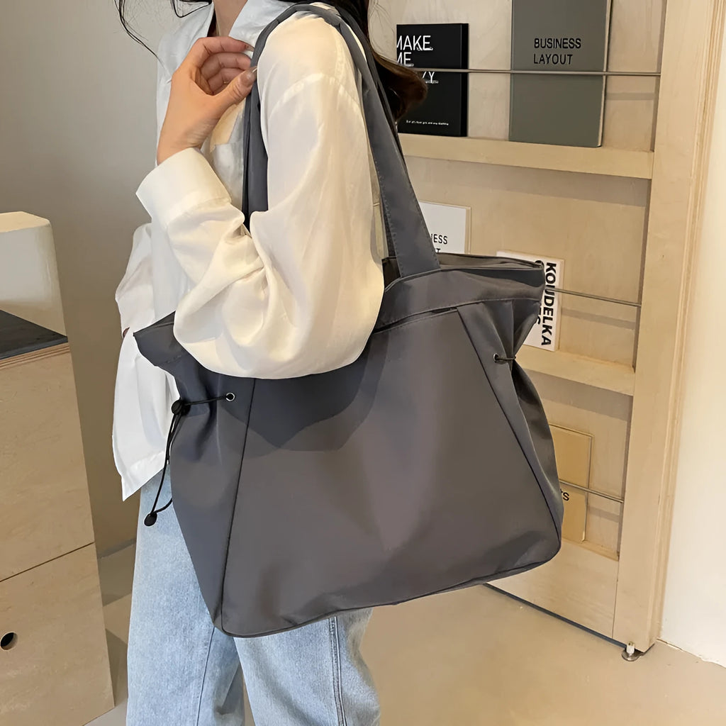 Soft Oxford cloth folding tote bag in a choice of five colours: black, brown, dark grey, light grey, and purple.